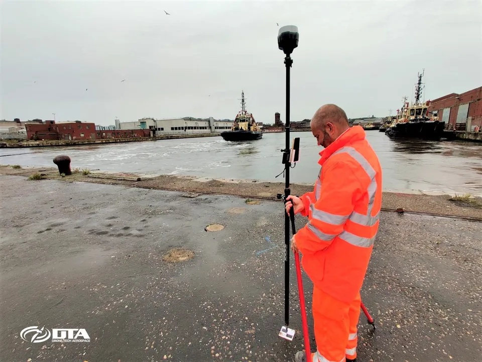Drone survey team taking ground control point readings during a topographical survey in Liverpool