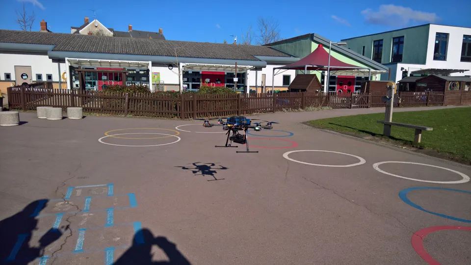 Drone climbing over a commercial roof during an inspection sequence in Swindon, Wiltshire