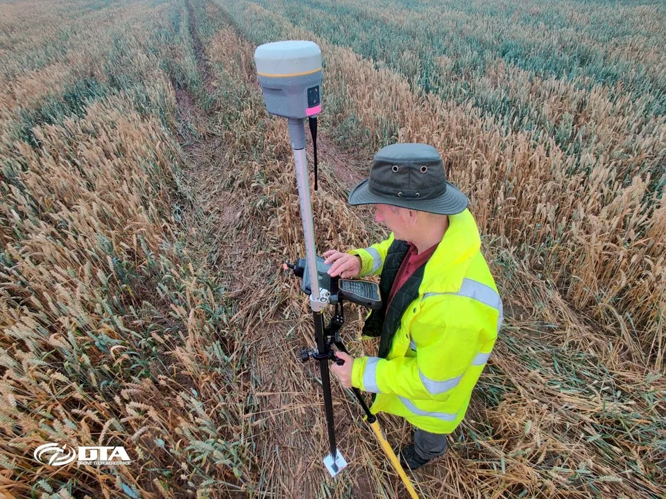 Drone survey team setting ground control point readings during a land survey in Doncaster