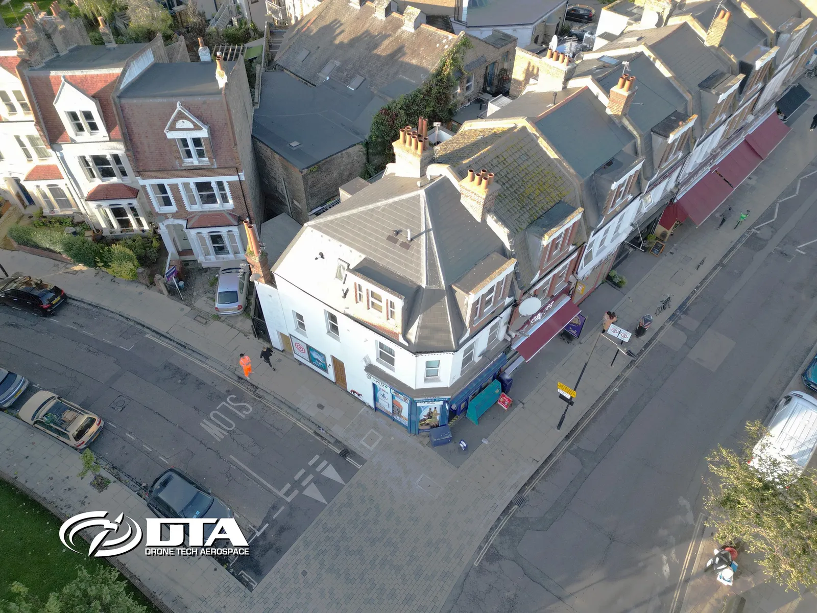 Aerial photograph looking down on a parade of shops and flats along a London street.