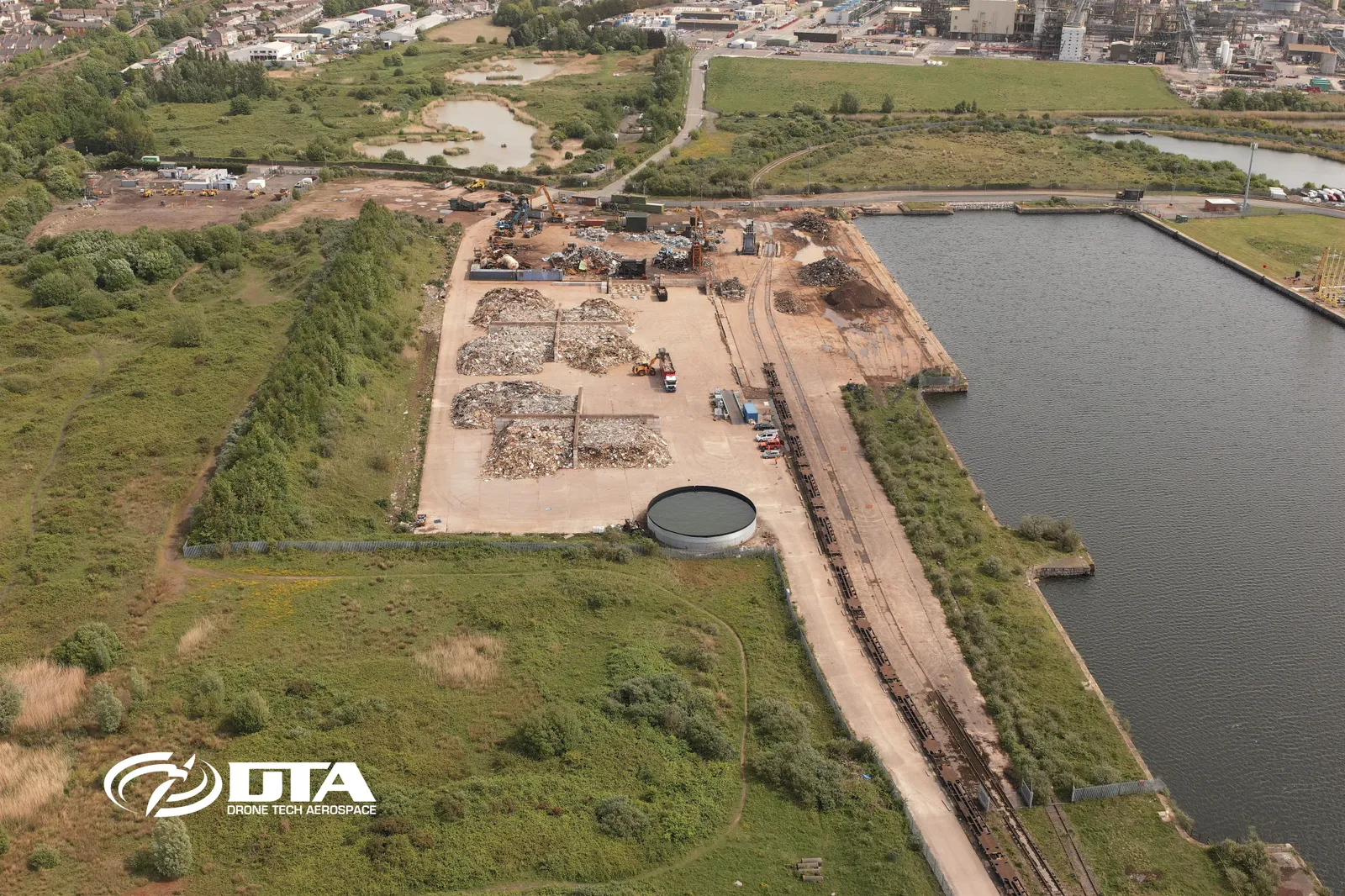Aerial photograph looking down over Barry Docks showing dockside stockpiles and quay infrastructure.