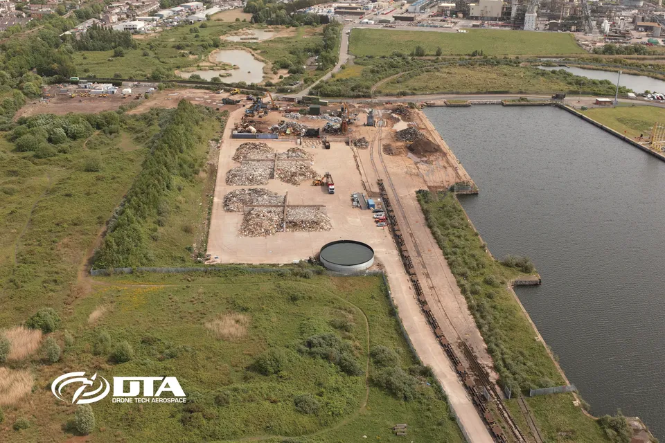 Aerial photograph looking down over Barry Docks showing dockside stockpiles and quay infrastructure.
