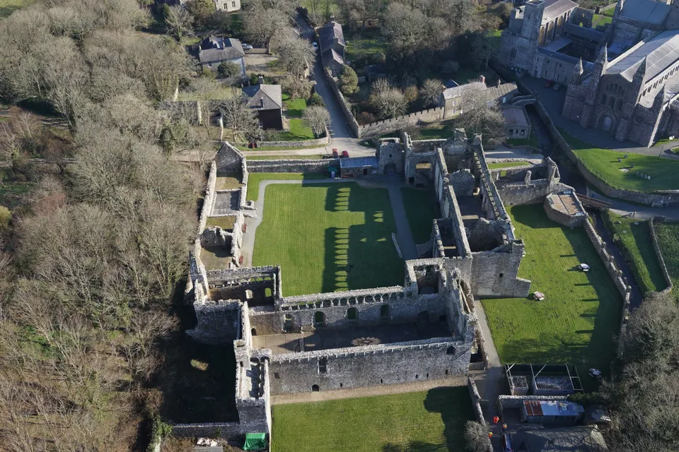 Close aerial photograph of weathered stone arches and window openings at a ruined palace.