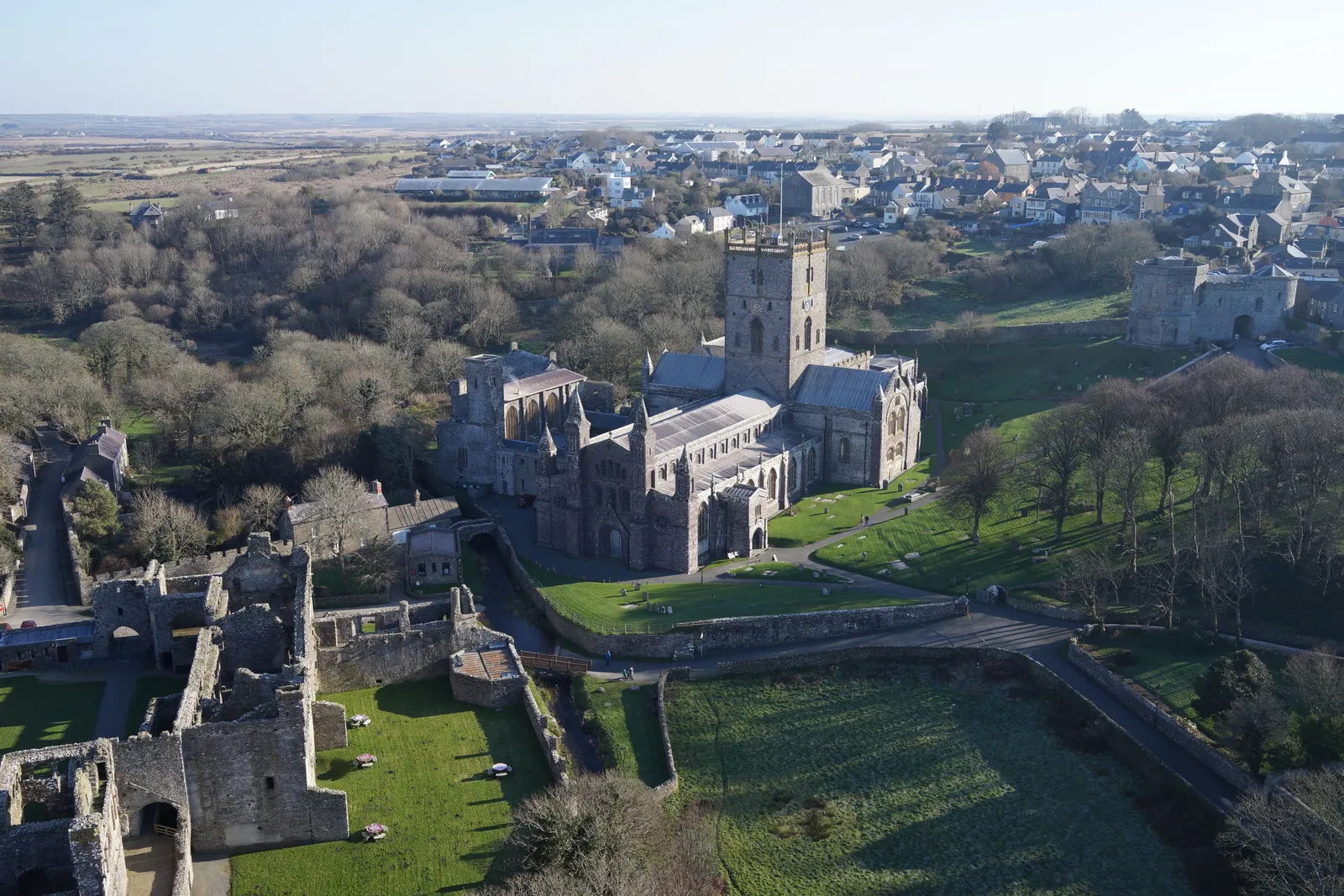 Aerial photograph of the arcaded wall and open courtyard of a ruined bishop's palace.