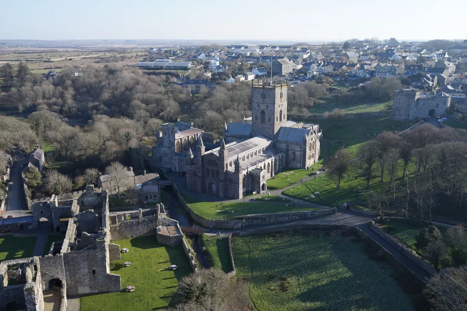 Aerial photograph of the arcaded wall and open courtyard of a ruined bishop's palace.