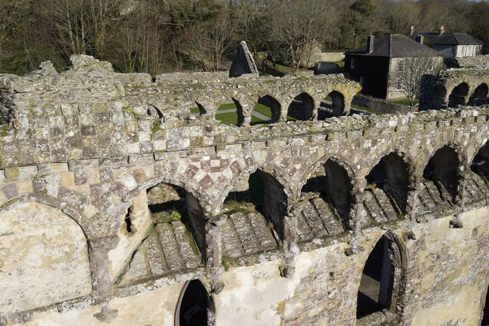 Aerial photograph of roofless stone ruins and courtyards at a medieval bishop's palace.