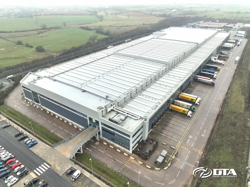 Aerial photograph of a large warehouse roof and yard at a distribution centre in Exeter.