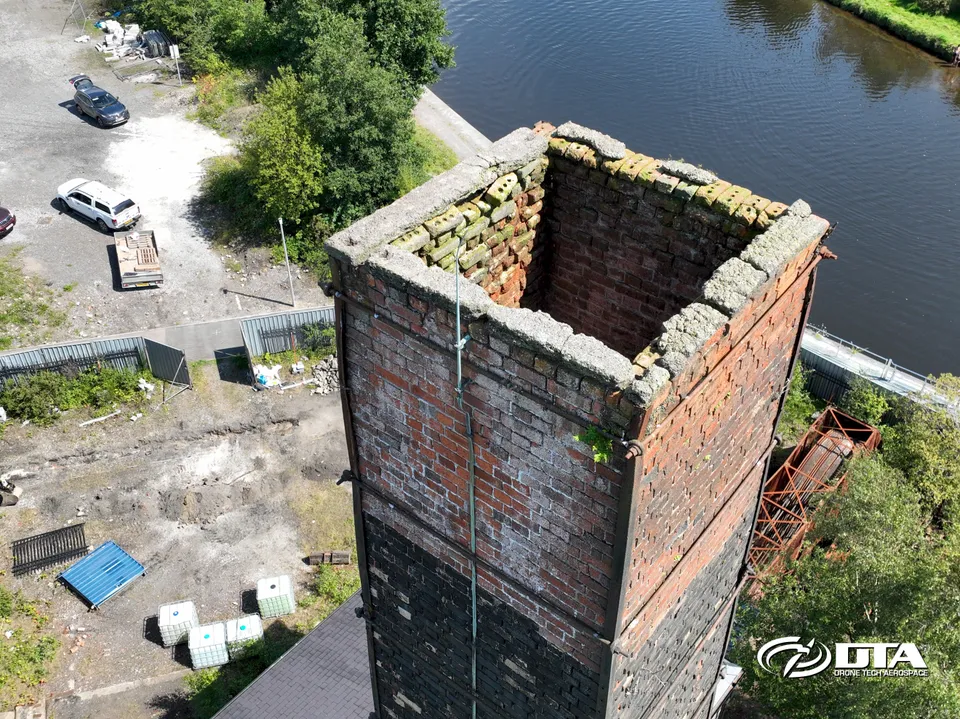 Aerial photograph showing the full elevation of a tall industrial chimney against the sky.