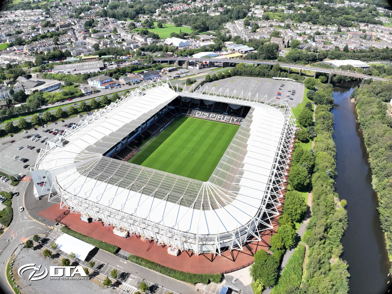 Aerial photograph of a football stadium bowl and surrounding car parks in Swansea.