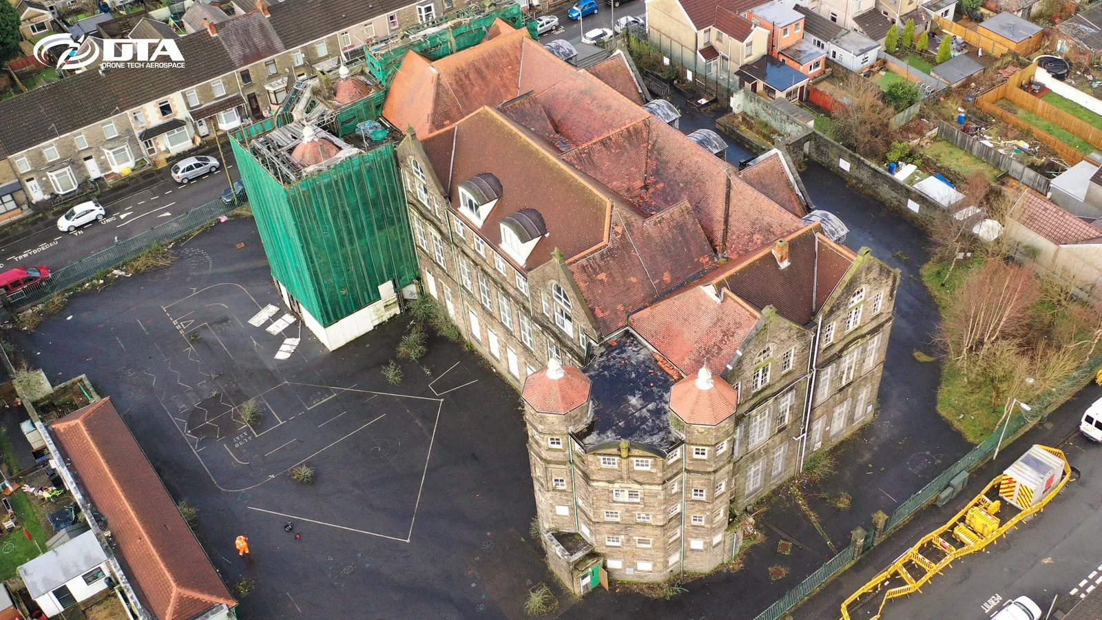 Angled aerial photograph of a school building and playground in Swansea.