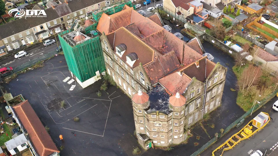 Angled aerial photograph of a school building and playground in Swansea.
