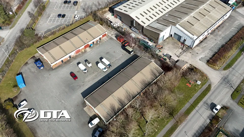 Aerial photograph looking down on a terrace of commercial units beside a road.