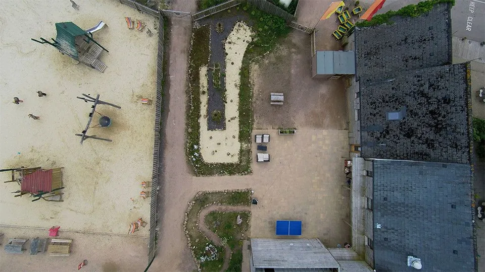 Aerial photograph of a ranch entrance with signage and driveway viewed from above.