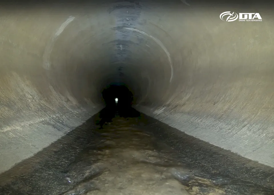 Photograph of an underwater ROV inspecting the inside of a concrete culvert.