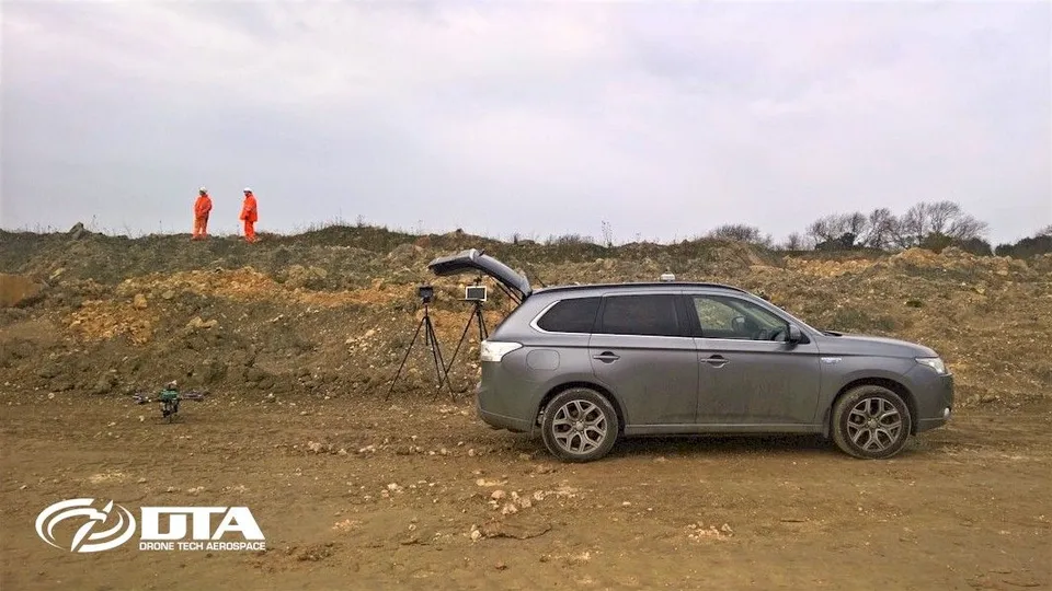 Photograph of a 4x4 survey vehicle parked at the edge of a quarry site.
