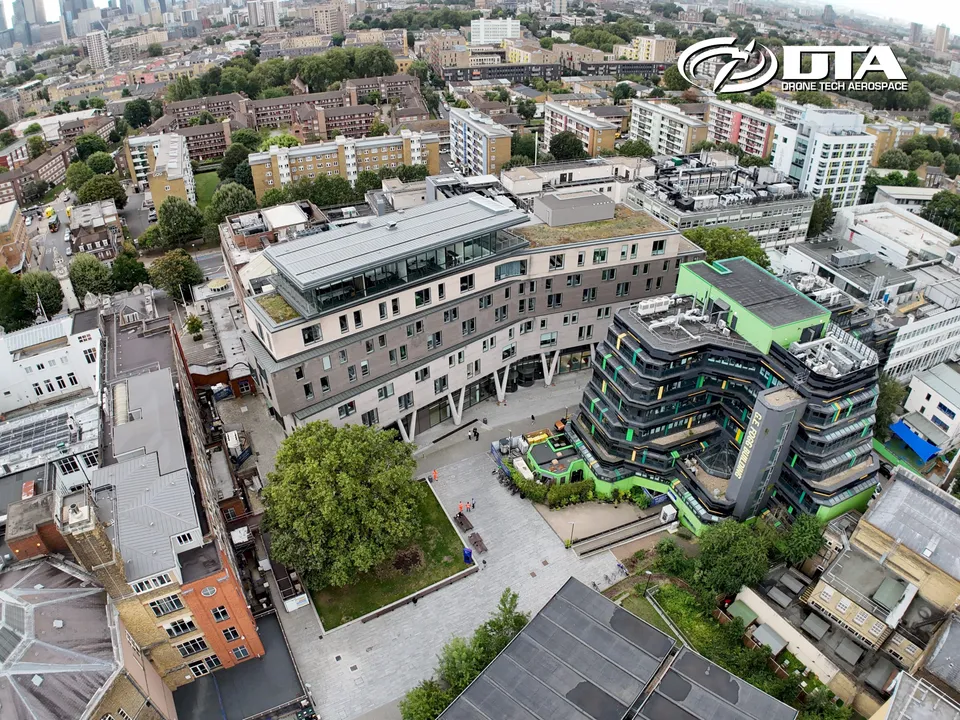 Aerial photograph of a modern university building with a curved glass facade.