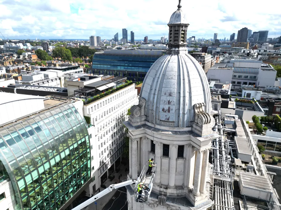 Aerial photograph of a mobile elevated work platform positioned against a tower structure in central London.