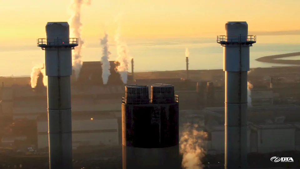 Aerial photograph looking closely at the top section of a tall industrial smoke stack.