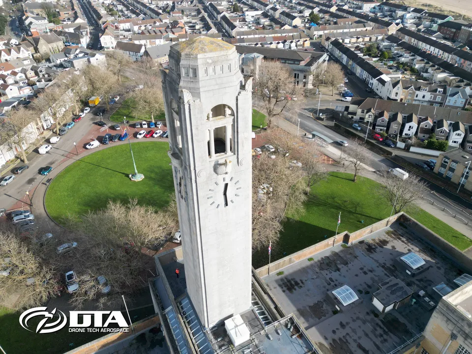 Aerial photograph looking up at a stone clocktower above a civic building in Swansea.
