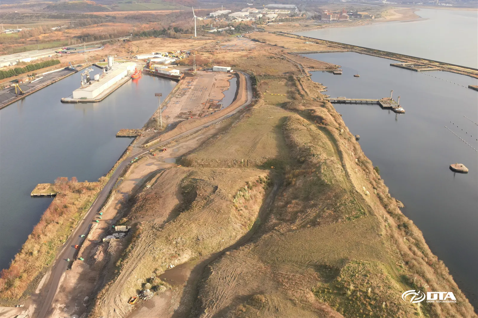 Aerial photograph looking down over a dockside stockpile area at Swansea Kings Dock, with cranes and dock infrastructure visible.
