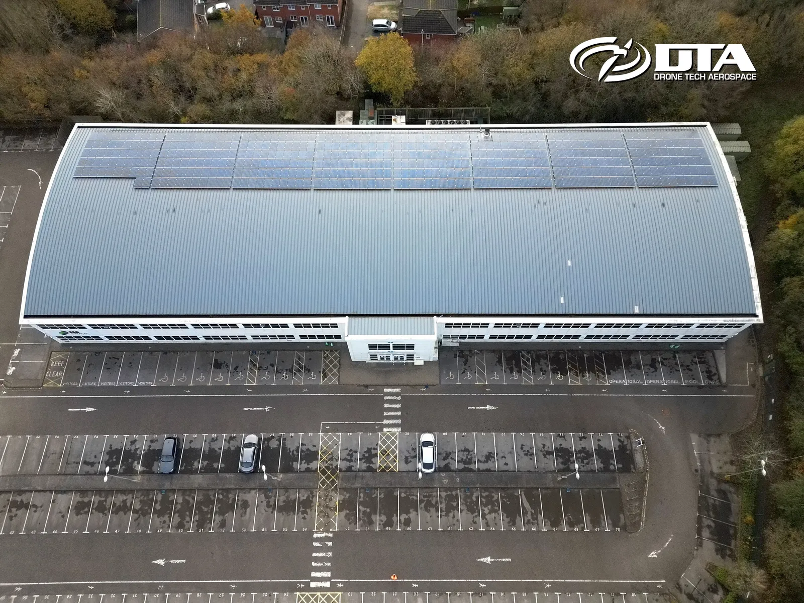 Aerial photograph looking down on the flat roof of an office building at a business park.