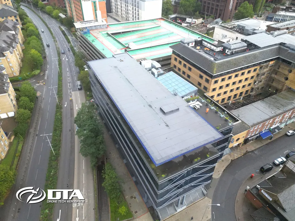 Aerial photograph looking down on a modern development building and surrounding streets.