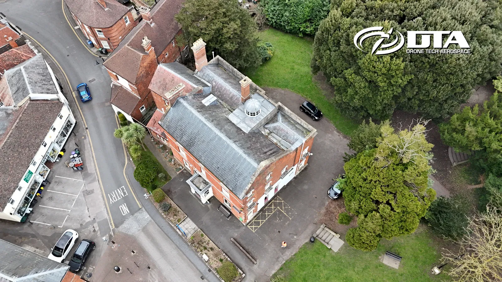 Aerial photograph looking down on a library building and its grounds on a town street.