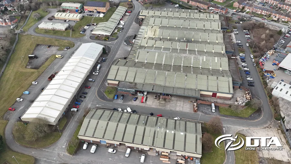 Aerial photograph looking down on a row of industrial estate units and yards.