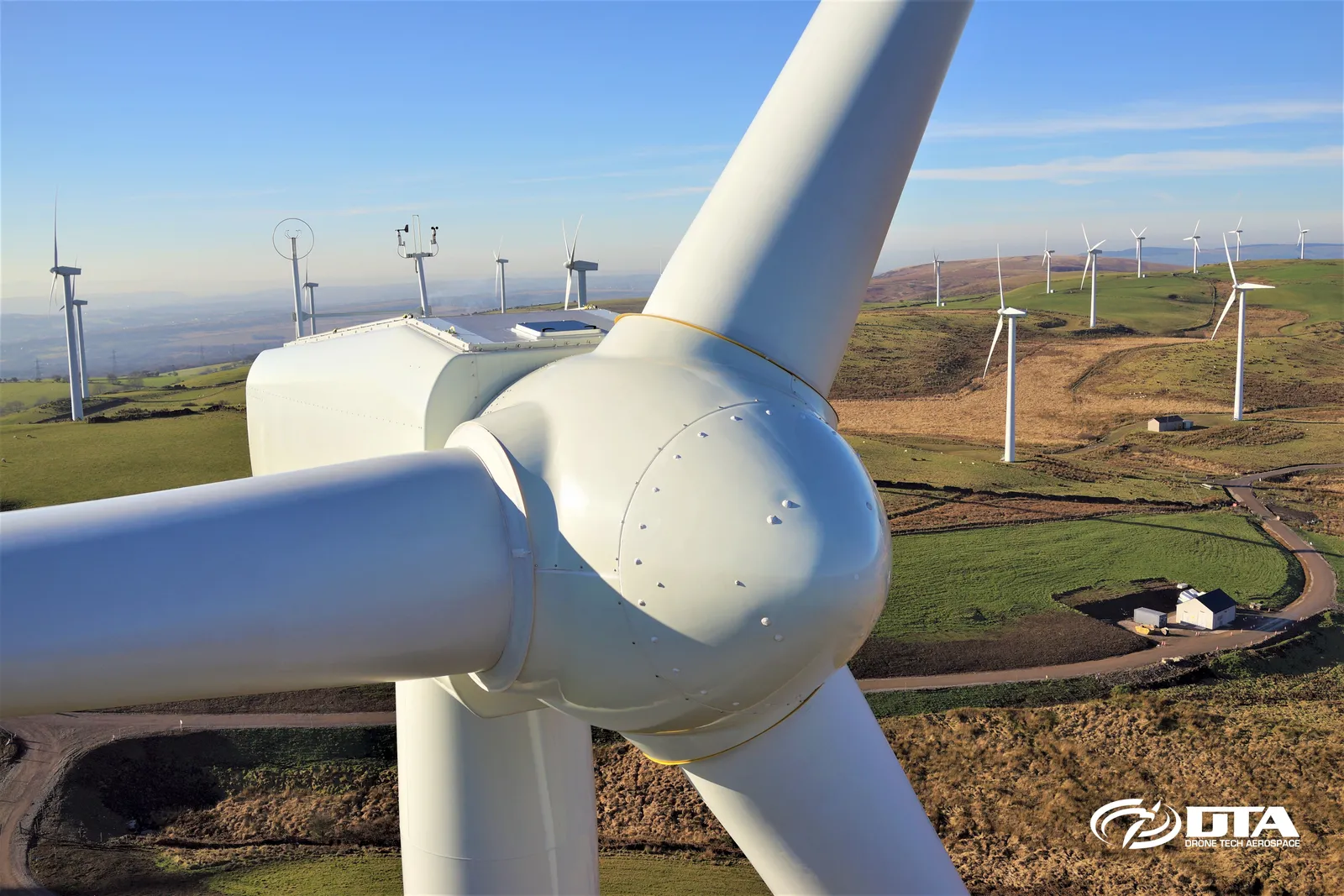 Close-up aerial photograph of a wind turbine blade and nacelle photographed from a hovering drone.