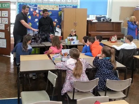 DTA team members demonstrating a drone to primary school pupils seated at their classroom desks