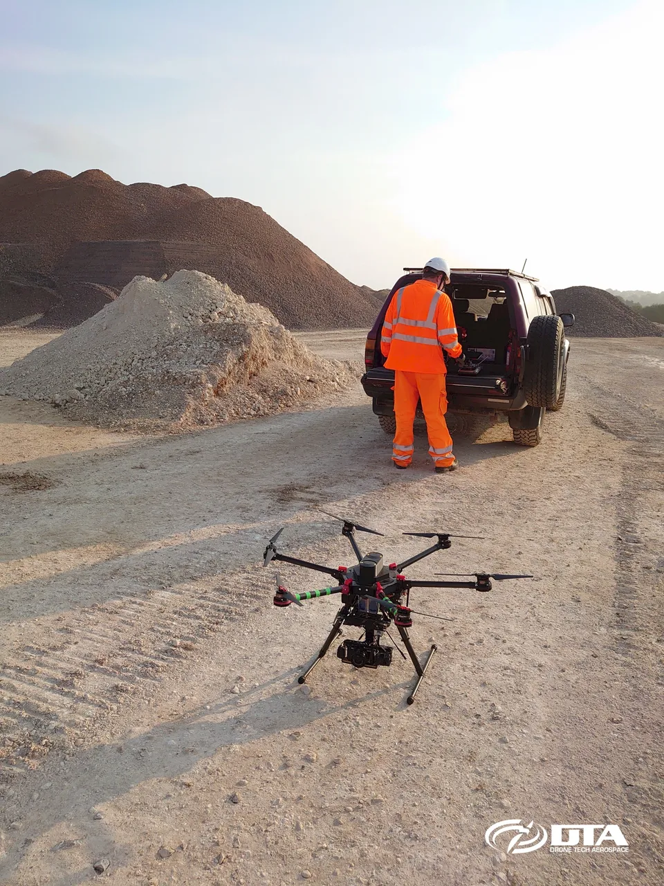 Aerial drone photograph looking down over a large-scale UK construction site during a topographical land survey